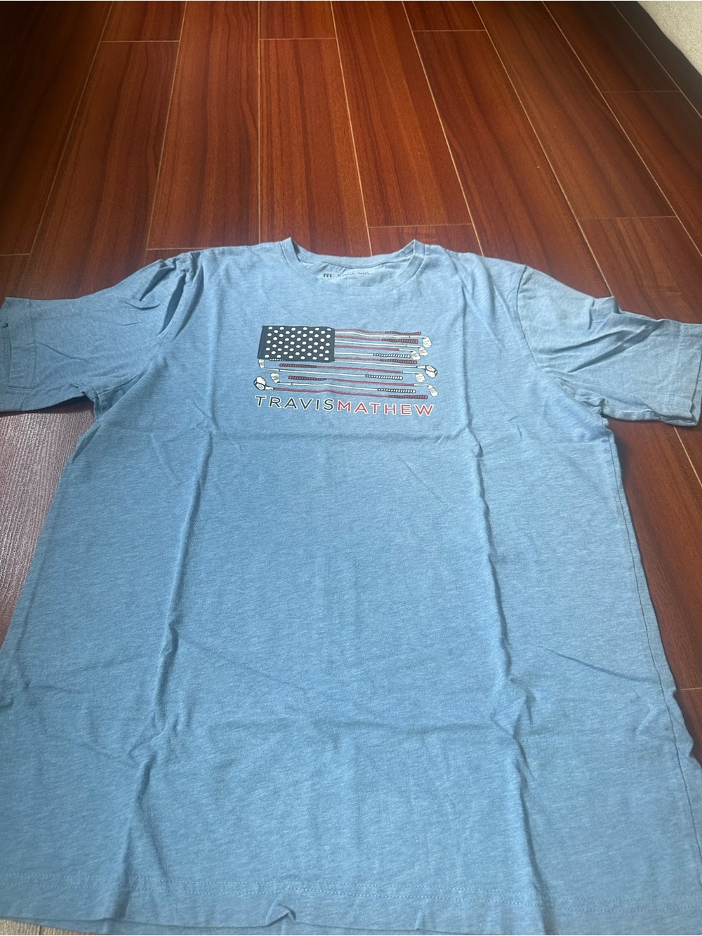 Travis Mathew Light Blue Short Sleeve Crew Tee with Flag Graphic